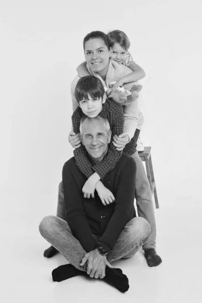 Un grupo de gente sonriente formó una columna. Hombre feliz entre las mujeres: adultos, niños, juguete. Concepto de regalo para niños, día de la familia — Foto de Stock