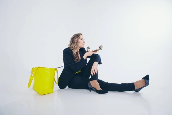 Het concept van werk in het kantoor, Business plan, mode-een gelukkige zakenvrouw in een zwart en geel pak glimlachend in de telefoon. Mooie vrouw op witte achtergrond — Stockfoto