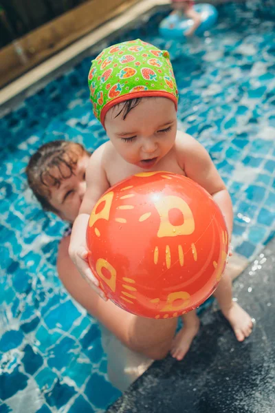 Les femmes enseignent à bébé à nager. Fille avec des jouets gonflables pour la piscine. Le concept d'enseignement de la natation, accessoires, loisirs — Photo