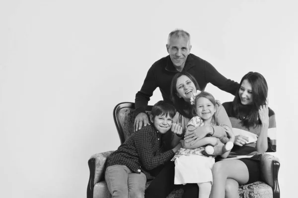 Concept d'enfance heureuse, famille, amour - groupe de personnes sur fond blanc : adultes et enfants avec des jouets assis sur le même canapé — Photo