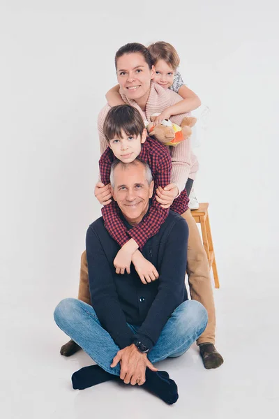 Un grupo de gente sonriente formó una columna. Hombre feliz entre las mujeres: adultos, niños, juguete. Concepto de regalo para niños, día de la familia — Foto de Stock