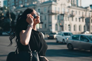 kentsel peyzaj arka planda güneş gözlüğü güzel bir kız portresi. Moda kavramı, yaşam tarzı