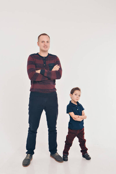 двое мужчин в одинаковых позах. Отец и сын. Концепция развития бизнеса, демонстрация прочности, преемственности
