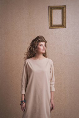 boş çerçeve yakınında gülümseyen güzel sevimli kız. Kopya alanı. Reklam için boş alan kavramı, metinlerin gösteri için modeller