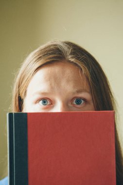 Bir kızın portresi: bir kadın bir kitabın arkasından dışarı bakar. Öğrenci edebiyatı yazmak için bir alan olarak kullanır. Gözlerinizi kapatın.