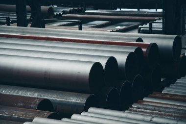 ağır sanayi konsepti, inşaat makineleri - büyük bir oda içinde uzun metal borular. Hangardaki yapı malzemeleri