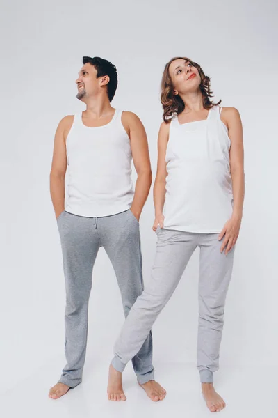 Två personer i identiska poser. En man och en gravid kvinna ser helt annorlunda ut. Begreppet hälsosam matsmältning, livsstil — Stockfoto