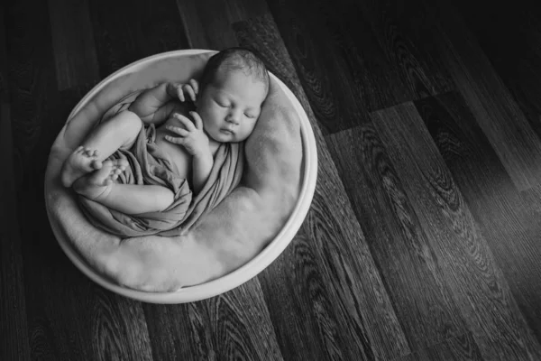 Nyfödda barnet insvept i en filt sova i en korg. begreppet barndom, sjukvård, IVF. Svartvitt foto — Stockfoto