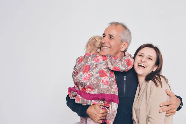 Foto familiar sobre fondo blanco: los padres pasan tiempo con sus hijos. Mamá y papá abrazan al bebé. el concepto de infancia, paternidad, maternidad, FIV — Foto de Stock