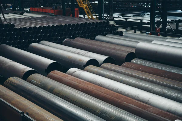 Concepto de la industria pesada, maquinaria de construcción tubos largos de metal dentro de una habitación grande. Materiales de construcción en el hangar — Foto de Stock