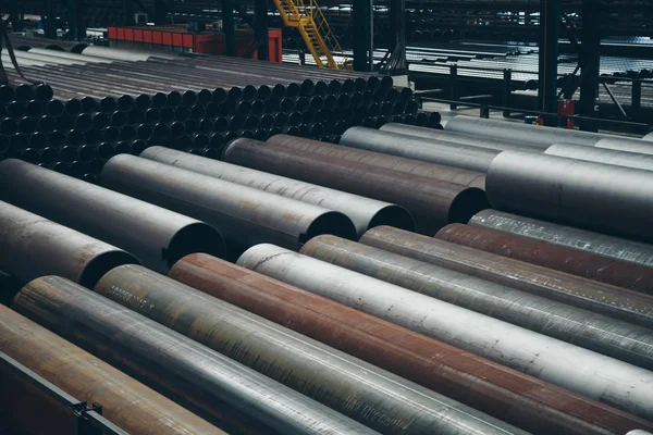 Heavy industry concept, construction machinery - long metal pipes inside a large room. Building materials in the hangar — Stock Photo, Image