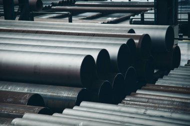 ağır sanayi konsepti, inşaat makineleri - büyük bir oda içinde uzun metal borular. Hangardaki yapı malzemeleri