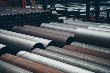 ağır sanayi konsepti, inşaat makineleri - büyük bir oda içinde uzun metal borular. Hangardaki yapı malzemeleri