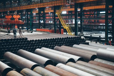 ağır sanayi konsepti, inşaat makineleri - büyük bir oda içinde uzun metal borular. Hangardaki yapı malzemeleri