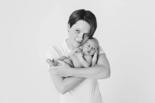 Fotó fekete-fehérben: az anya a karjaiban tartja a fiát. Családi portré: egy nő egy gyerekkel. Egészségügyi koncepció: egészséges család — Stock Fotó
