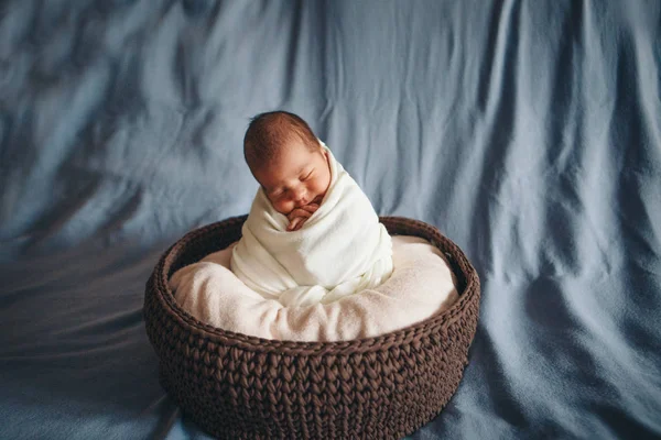 Newborn baby wrapped in a blanket sleeping in a basket. concept of childhood, healthcare, IVF. Black and white photo — Stock Photo, Image