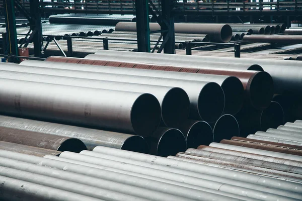 Concepto de la industria pesada, maquinaria de construcción tubos largos de metal dentro de una habitación grande. Materiales de construcción en el hangar — Foto de Stock