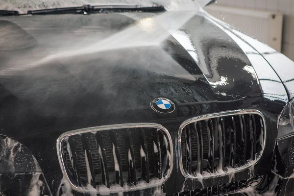 Reklam araba yıkama, Moskova, 1.11.2018: yüzey temizliği. BMW motor şirketi rozeti siyah arabanın önünde. Alman şirketi