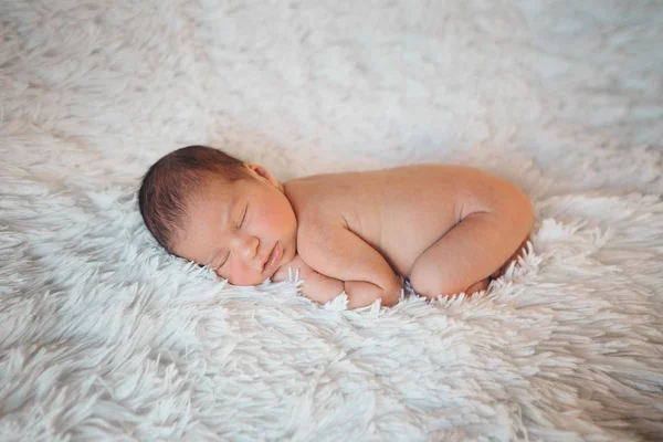 Naked newborn baby lying on a white background. Imitation of a baby in the womb. beautiful little girl sleeping lying on her stomach. — Stockfoto