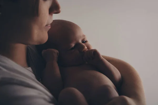 Foto in bianco e nero: la madre tiene il figlio tra le braccia. Ritratto di famiglia: una donna con un bambino. Concetto di assistenza sanitaria: famiglia sana — Foto Stock