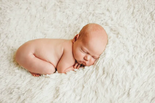 Nagiego noworodka leżącego na białym tle. Naśladowanie dziecka w łonie matki. piękna dziewczynka śpi leżąc na brzuchu. — Zdjęcie stockowe