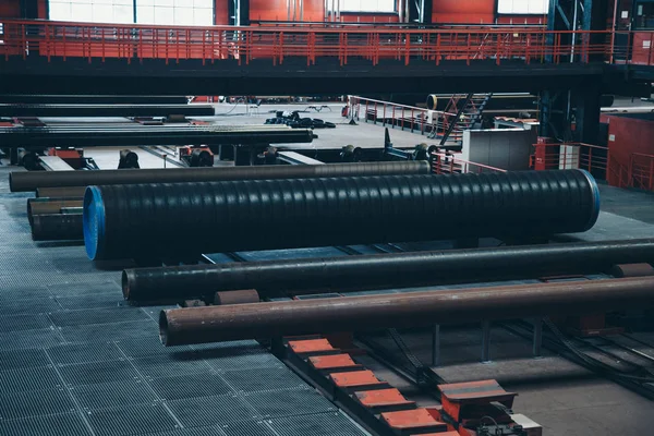 Conceito da indústria pesada, máquinas de construção tubos de metal longos dentro de uma grande sala. Materiais de construção em hangar — Fotografia de Stock