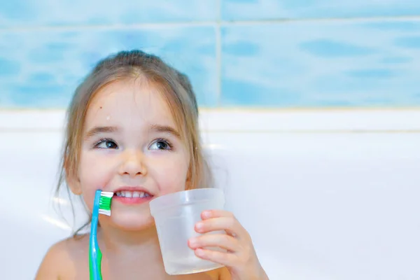 小さな女の子が歯を磨きバスルームで口をすすいでいます 歯ブラシを持った子供の肖像画です — ストック写真
