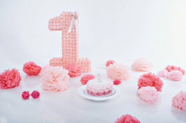 Festivalsel iç mekan konsepti, bayram nitelikleri, dekoratif unsurlar: bir numara, çiçekler, beyaz arka plandaki kuşlar için bir kafes. Pembe.