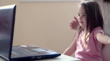 Küçük çocuk bilgisayarda oynuyor. Dahi Çocuk iş planlama, ev işi, karantina, kendi kendini izole etme, koronavirüsten koruma, virüs, ev eğitimi, mesafe çalışması tekniklerini öğrenir..