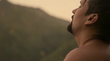 Islak bir adamın portresi. Damlalar yüzüme damlıyor. Sıkı çalışmadan sonra mutlu bir insan. Güç egzersizleri, kilo verme, bronzlaşma, yüzme, banyo sonrası vücut buharı, yorgunluk.