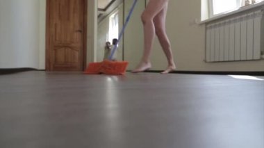 Anne paspas ile yerleri paspaslıyor ve çocuk oynarken dans ediyor. Çocuklar için tedavi odaları