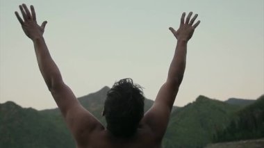 Islak bir adamın portresi. Damlalar yüzüme damlıyor. Adam ellerini kaldırıyor.
