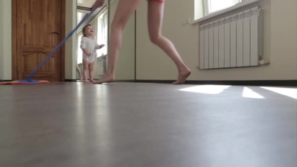 Matka Myje Podłogę Mop Tańczy Podczas Gdy Dziecko Się Bawi — Wideo stockowe