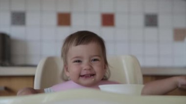 Elleriyle bebek maması yiyen bir çocuğun portresi. Yüzüme yemek bulaştı.