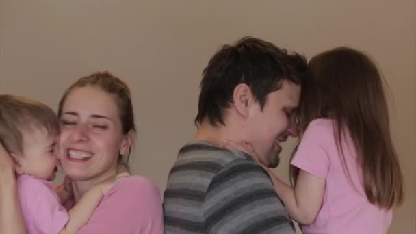 父亲节 母亲节 家庭日 儿童节 爸爸和妈妈抱着孩子们 拥抱他们 女孩亲吻她们的父母 我爱你 — 图库视频影像
