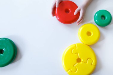 Çocuk piramidin detaylarıyla oynuyor. Beyaz arka plandaki oyuncaktan çok renkli detaylar. iyi motor beceriler geliştirme, eğitim oyunları