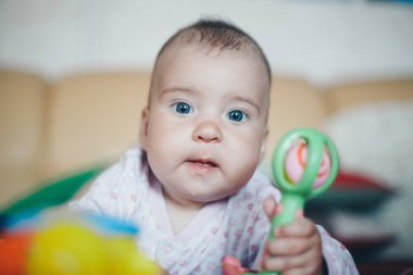 Bebek çıngırağı olan bir çocuğun portresi. Kız oyun oynuyor. İyi motor beceri geliştirme kavramı, eğitim oyunları, çocukluk, çocuk günü, anaokulu telif alanı