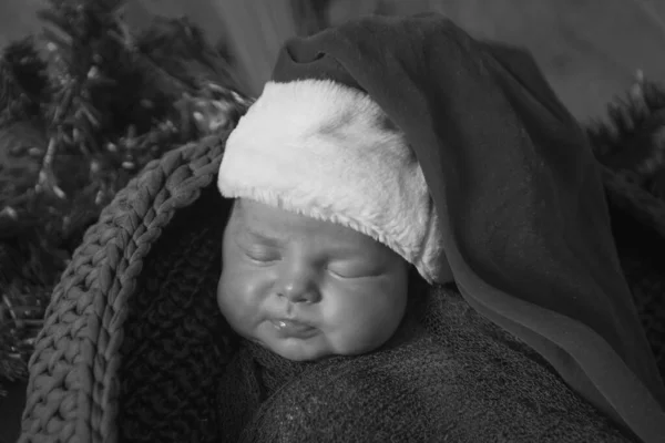 Egy Újszülött Pomponos Sapkában Alszik Egy Karácsonyi Koszorúban — Stock Fotó