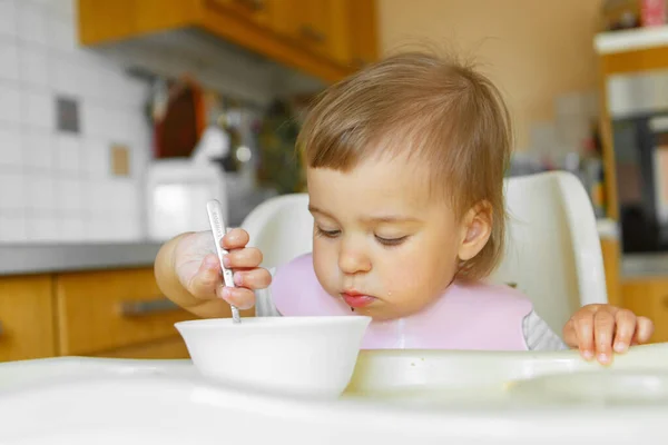 スプーンで赤ちゃんの食べ物を食べる子供の肖像画です 私の顔は食べ物で汚れています — ストック写真