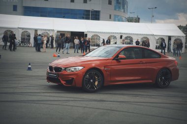 Reklam BMW, Moskova, 1.11.2018: kırmızı araba modelinin tanıtımı, test pistindeki arabalar, tekerleklerin altından çıkan toz, yoldaki raylar, yarış, sürücü kursunda sürüş eğitimi, şehrin etrafında teslimat, taksi