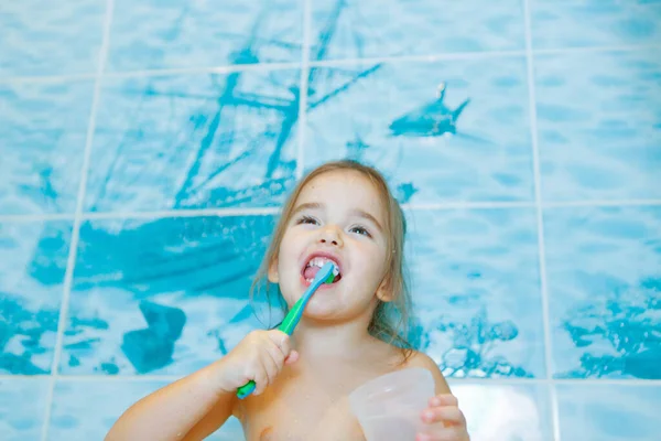 a little girl brushes her teeth and rinses her mouth in the bathroom. portrait of a child with a toothbrush