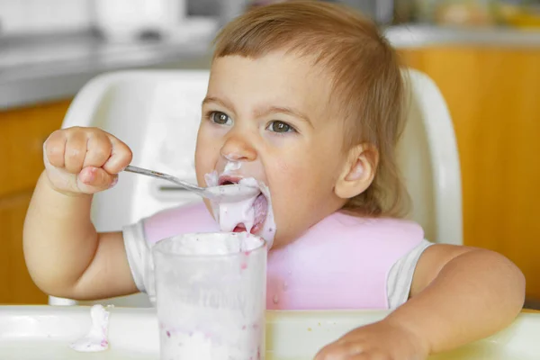 スプーンで赤ちゃんの食べ物を食べる子供の肖像画です 私の顔は食べ物で汚れています — ストック写真