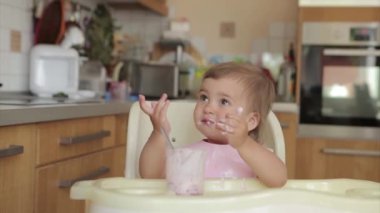 Kaşığıyla bebek maması yiyen bir çocuğun portresi. Yüzüme yemek bulaştı.