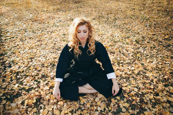 a woman meditates in the autumn forest. spiritual practices. postures of yoga