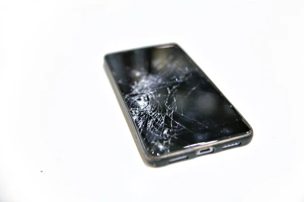 Broken phone glass. broken black smartphone. Close up on white background