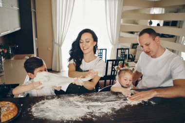 Aile pasta yapar. Çocuklar un ile kaplıydı. Fırında akşam yemeği. Mutfakta ziyafet