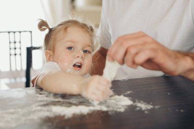 Bebek pasta yapıyor. Çocuklar un ile kaplıydı. Fırında akşam yemeği. Mutfakta ziyafet