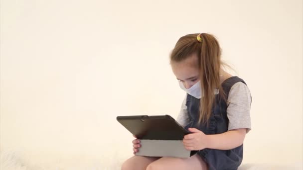 어린이등교 유행성 전염병 의료용 마스크를 원격으로 배우는 어린이 소녀가 노트북을 — 비디오