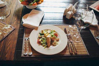 Kızarmış chiken, bıldırcın yumurtası, marul yaprağı, tost, parmesan, domates ve krema soslu klasik Sezar salatası servis edilen masaya yakın. İtalyan mutfağı