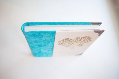 Beyaz arka planda yakın plan günlüğü. Kapağı beyaz ve mavi. En iyi hediye - bir fotoğraf albümü.